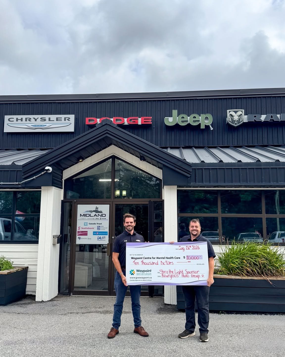 David Clayton, right, and a colleague outside Midland Chrysler holding a $10,000 cheque from Bourgeois Auto Group to Waypoint Centre for Mental Health Care
